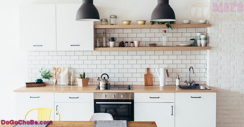 Modern New Light Interior Of Kitchen With White Furniture And Dining Table.